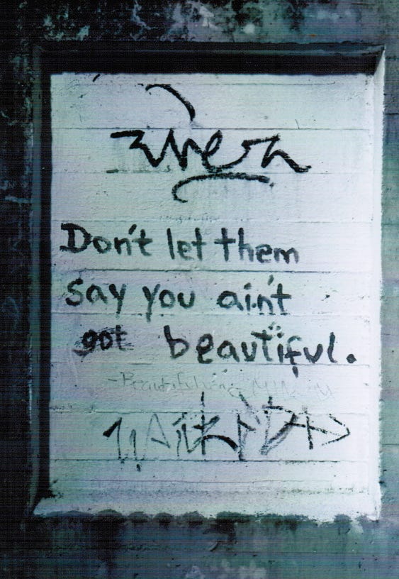 Das Schwarz-Weiß-Foto zeigt ein Graffito mit der Aufschrift "Don't let them say you ain't beautiful."