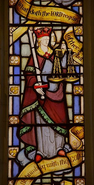 Stained glass window with a person holding scales

Description automatically generated