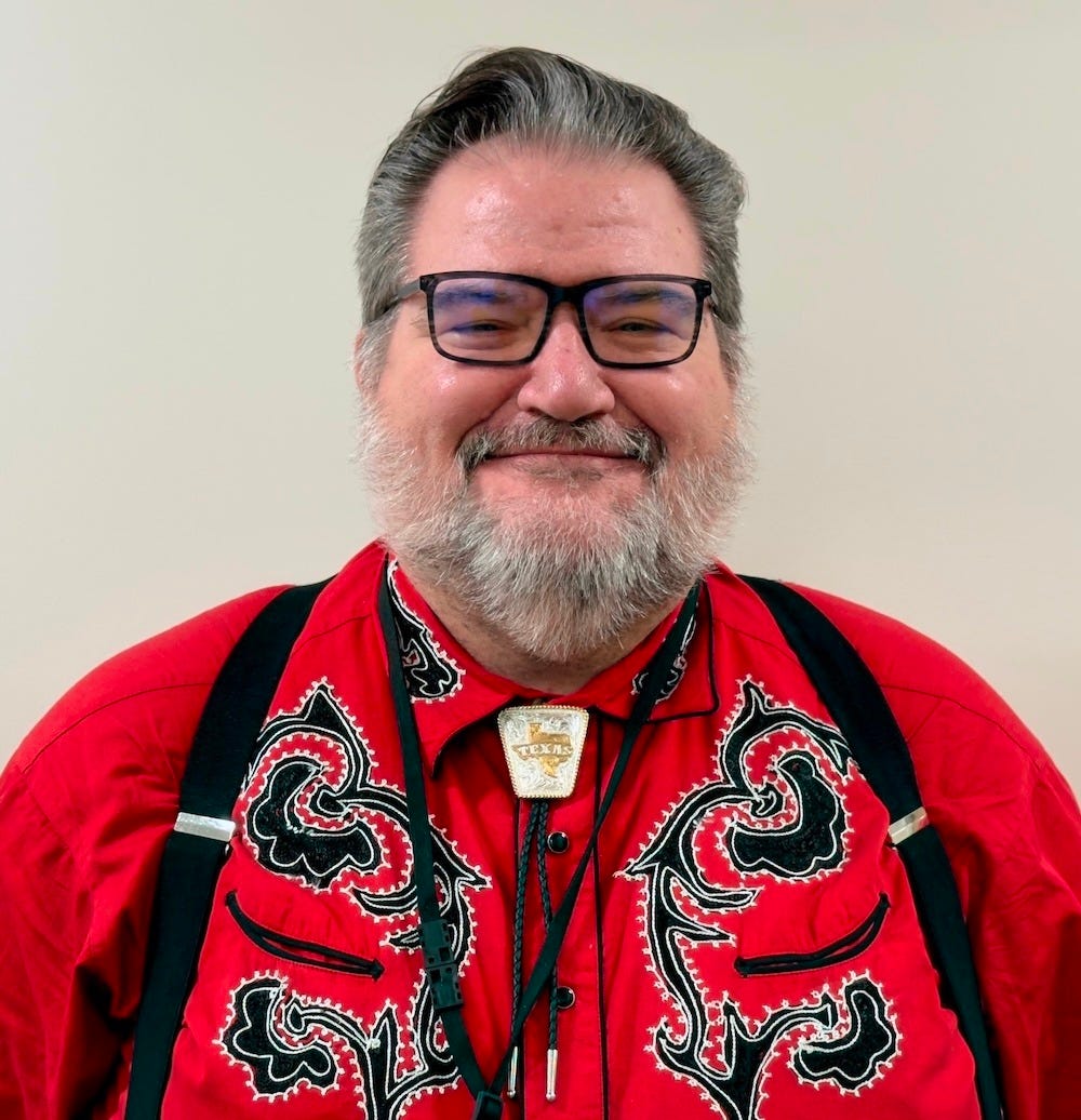 Picture of me in a red embroidered Western-style shirt, black suspenders, a Texas bolo tie, and glasses. I have a full beard as well. Picture of me in a red embroidered Western-style shirt, black suspenders, a Texas bolo tie, and glasses. I have a full beard as well.