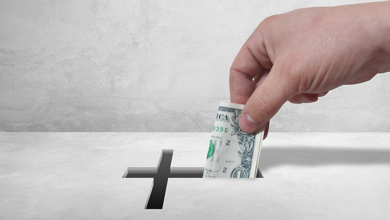 Putting money into a tithe or offering box Putting money into a tithe or offering box
