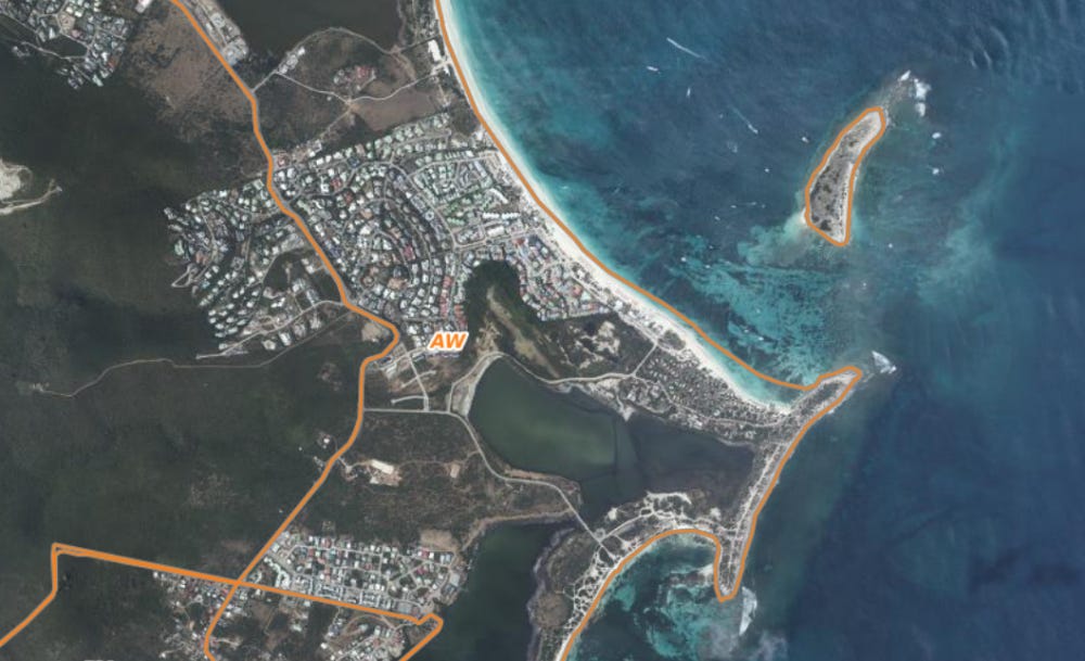 An aerial view of Orient Bay beach on the island of Saint Martin, showing the shoreline and surrounding landscape.