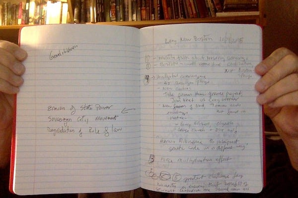 Photo of a notebook held open two pages covered in barely legible scribbles.