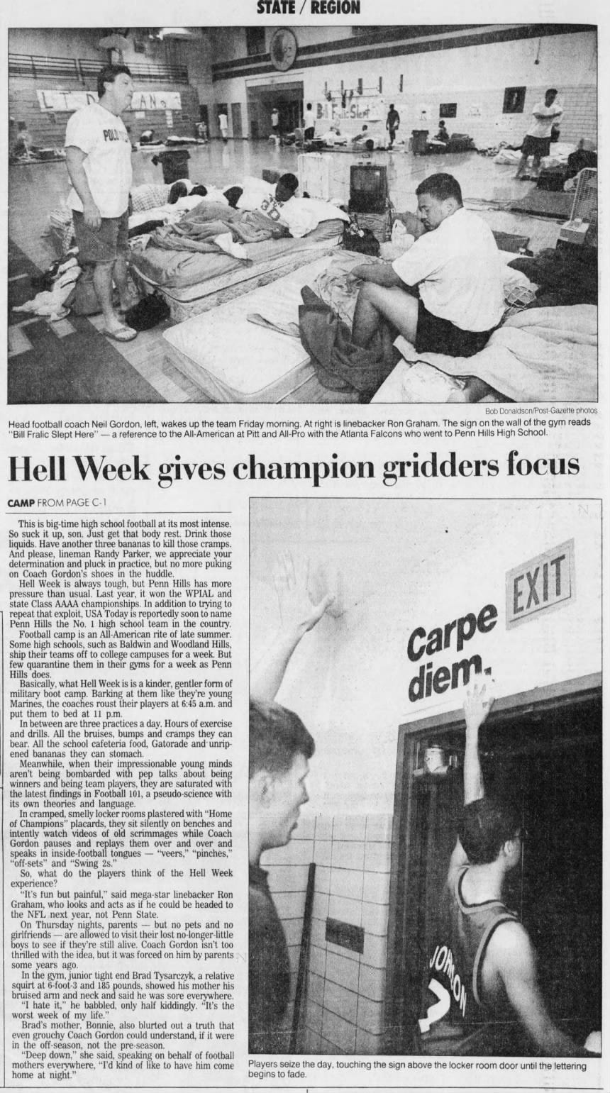 Bob Donaldson/Post Gazette photos Head football coach Neil Gordon, left, wakes up the team Friday morning. At right is linebacker Ron Graham. The sign on the wall of the gym reads "Bill Fralic Slept Here" - a reference to the All-American at Pitt and All-Pro with the Atlanta Falcons who went to Penn Hills High School. Hell Week gives champion gridders focus This is big-time high school football at its most intense. So suck it up, son. Just get that body rest. Drink those liquids. Have another three bananas to kill those cramps. And please, lineman Randy Parker, we appreciate your determination and pluck in practice, but no more puking on Coach Gordon's shoes in the huddle. Hell Week is always tough, but Penn Hills has more pressure than usual. Last year, it won the WPIAL and state Class AAAA championships. In addition to trying to repeat that exploit, USA Today is reportedly soon to name Penn Hills the No. 1 high school team in the country. Football camp is an All -American rite of late summer. Some high schools, such as Baldwin and Woodland Hills, ship their teams off to college campuses for a week. But few quarantine them in their gyms for a week as Penn Hills does. Basically, what Hell Week is is a kinder, gentler form of military boot camp. Barking at them like they're young Marines, the coaches roust their players at 6:45 a.m. and put them to bed at 11 p.m. In between are three practices a day. Hours of exercise and drills. All the bruises, bumps and cramps they can bear. All the school cafeteria food, Gatorade and unripened bananas they can stomach. Meanwhile, when their impressionable young minds aren't being bombarded with pep talks about being winners and being team players, they are saturated with the latest findings in Football 101, a pseudo-science with its own theories and language. In cramped, smelly locker rooms plastered with "Home of Champions" placards, they sit silently on benches and intently watch videos of old scrimmages while Coach Gordon pauses and replays them over and over and speaks in inside-football tongues - "veers," "pinches," "off-sets" and "Swing 2s." So, what do the players think of the Hell Week experience? "It's fun but painful," said mega-star linebacker Ron Graham, who looks and acts as if he could be headed to the NFL next year, not Penn State. On Thursday nights, parents - but no pets and no girlfriends - are allowed to visit their lost no-longer-little boys to see if they're still alive. Coach Gordon isn't too thrilled with the idea, but it was forced on him by parents some years ago. In the gym, junior tight end Brad Tysarczyk, a relative squirt at 6-foot-3 and 185 pounds, showed his mother his bruised arm and neck and said he was sore everywhere. "I hate it," he babbled, only half kiddingly. "It's the worst week of my life." Brad's mother, Bonnie, also blurted out a truth that even grouchy Coach Gordon could understand, if it were in the off-season, not the pre-season. "Deep down," she said, speaking on behalf of football mothers everywhere, "I'd kind of like to have him come Players seize the home at night." begins to fade. STATE / REGION CAMP FROM PAGE C-1 EXIT Carpe day, touching the sign above the locker room door until the lettering