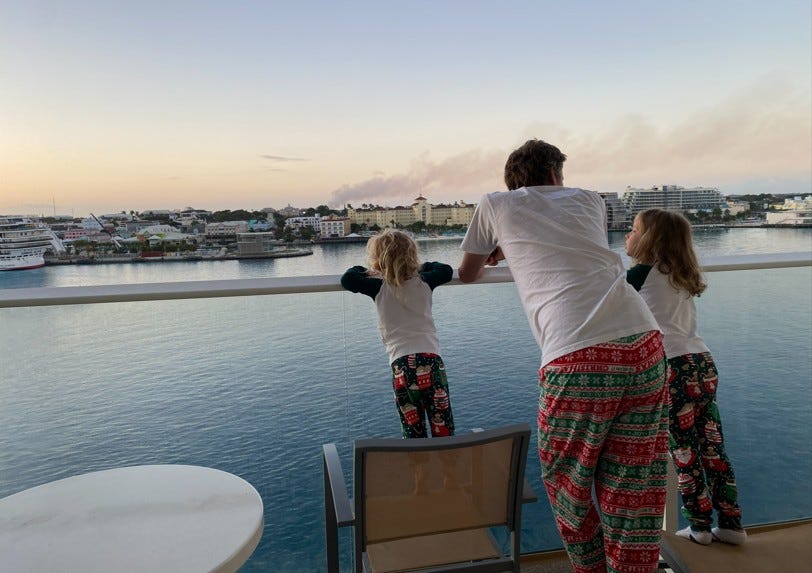 a dad with his two children watching a cruise ship dock in Nassau, Bahamas from a Junior Suite Balcony a dad with his two children watching a cruise ship dock in Nassau, Bahamas from a Junior Suite Balcony