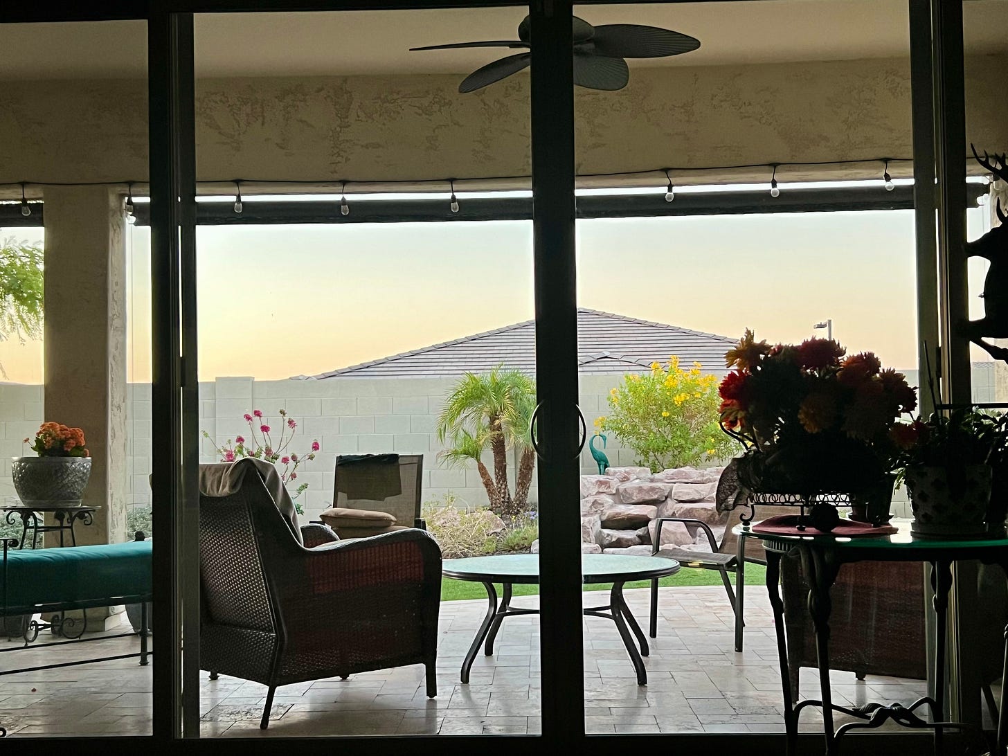 view from inside to a furnished patio and back yard