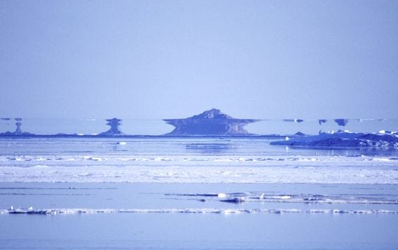 This may contain: an island in the middle of water with ice floes floating on it's surface