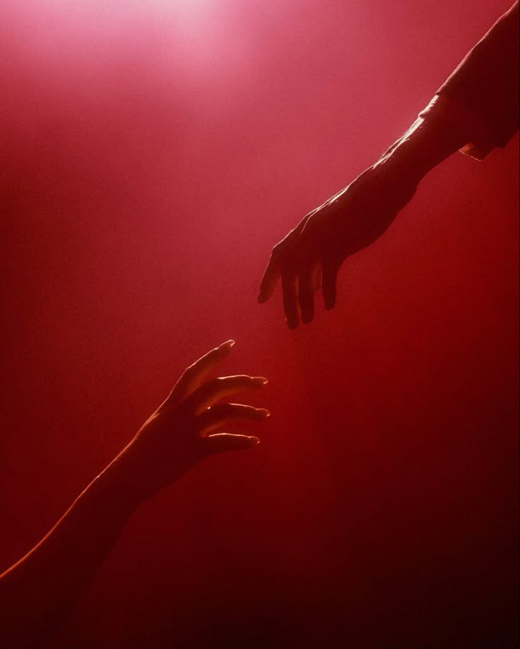 This may contain: two hands reaching out towards each other on a red background with light coming from behind This may contain: two hands reaching out towards each other on a red background with light coming from behind