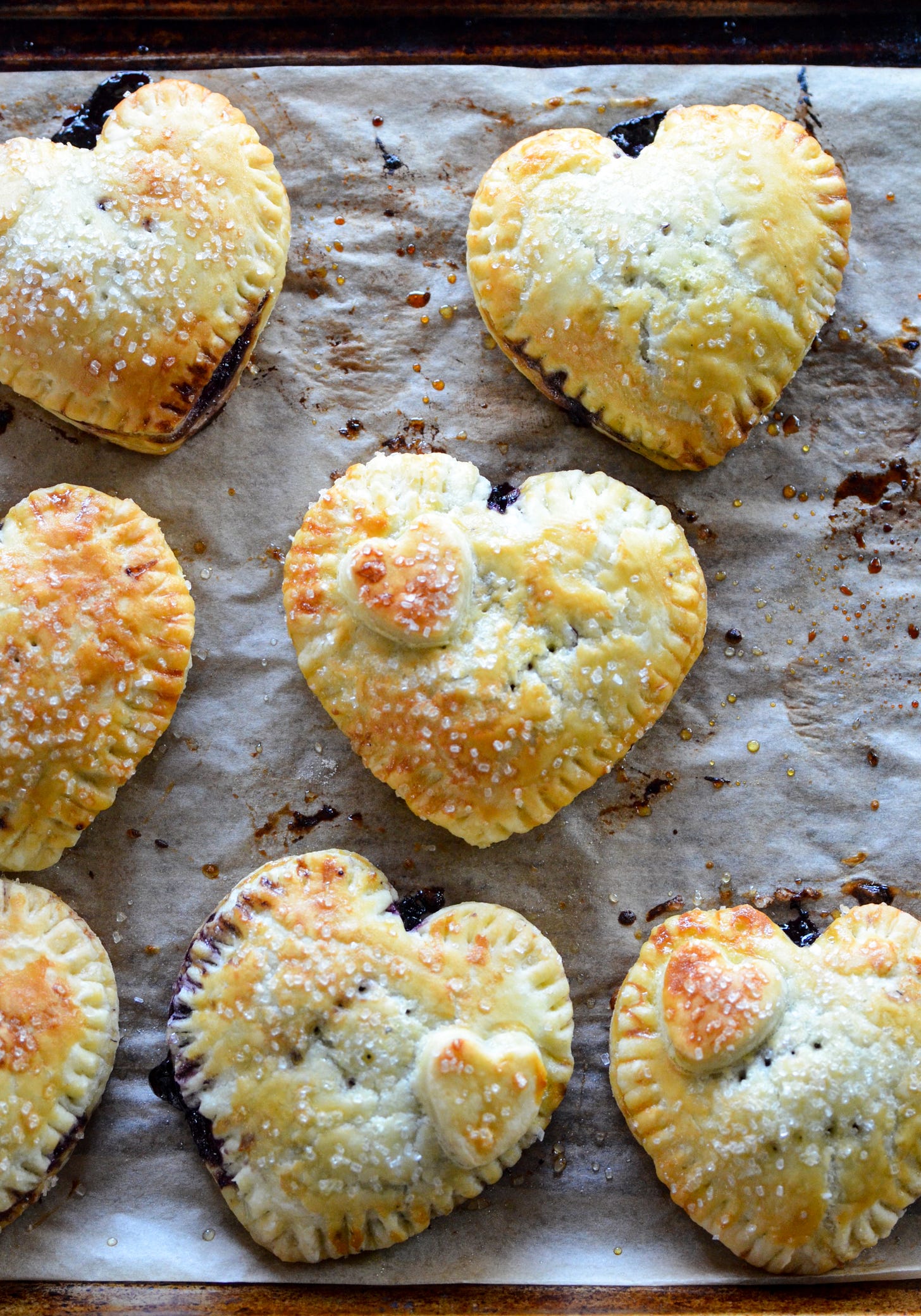 Heart shaped blueberry hand pies on a baking sheet