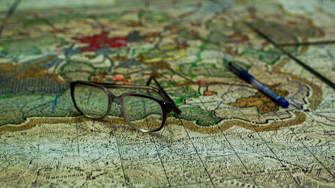 a pair of glasses sitting on top of a map a pair of glasses sitting on top of a map