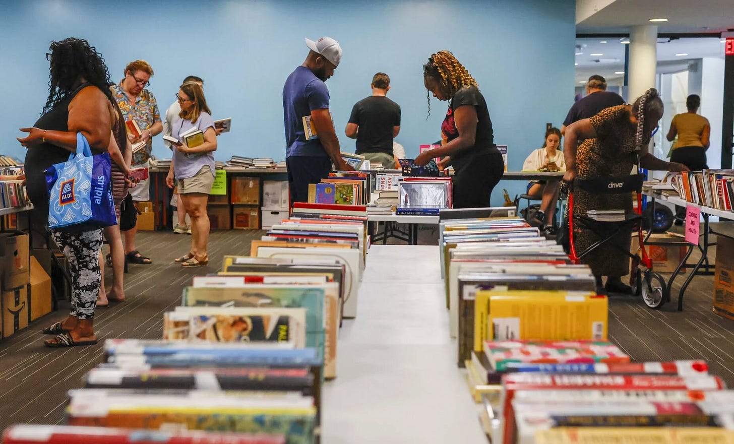 May be an image of newsstand, crowd and text May be an image of newsstand, crowd and text