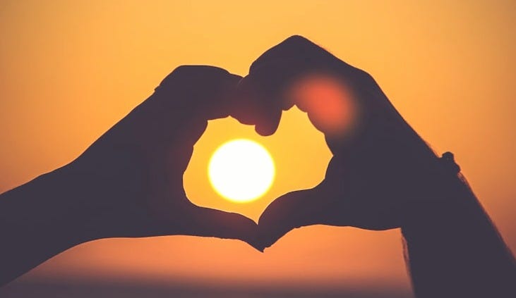 silhouette of person's hands forming heart