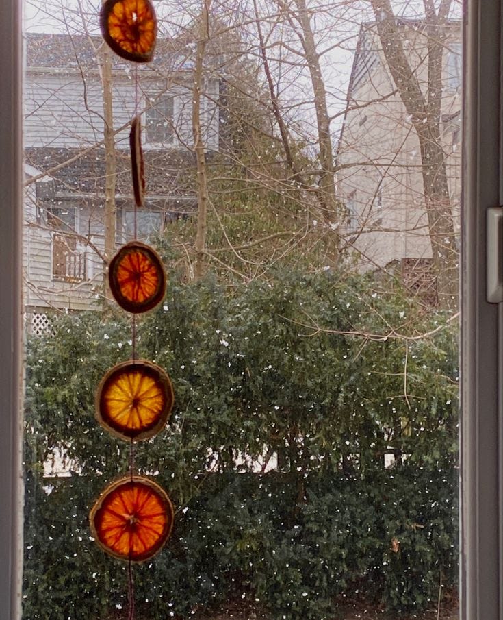 This may contain: an open window with three stained glass sun catchers hanging from it's sides