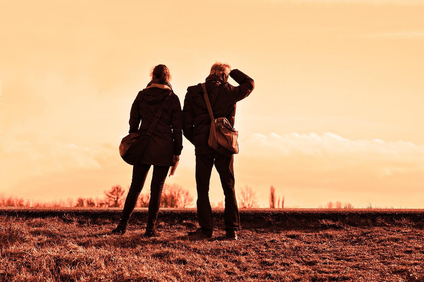 A married couple stand together and survey the horizon