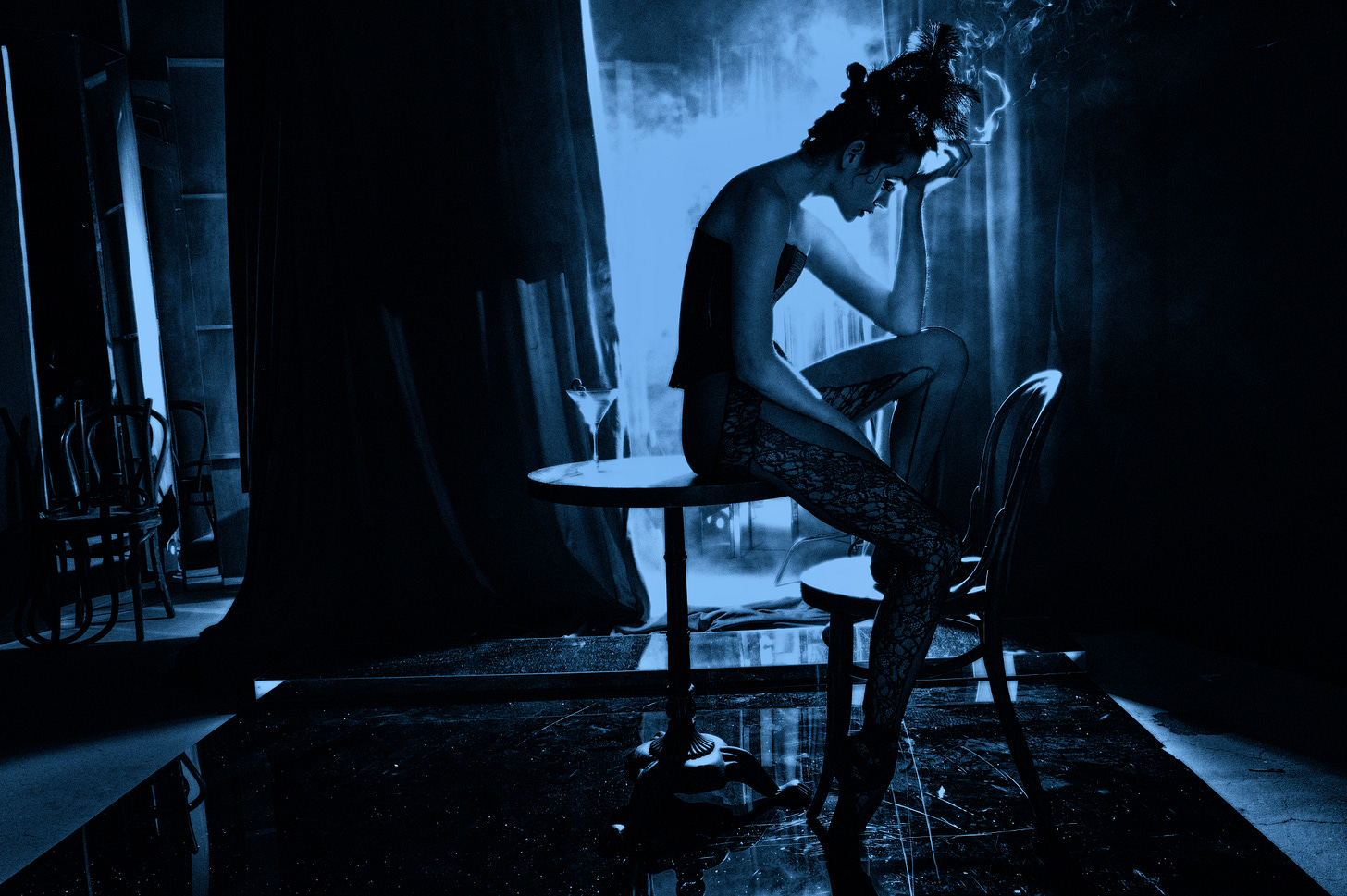 A lithsome dance sits atop a table in a nightclub