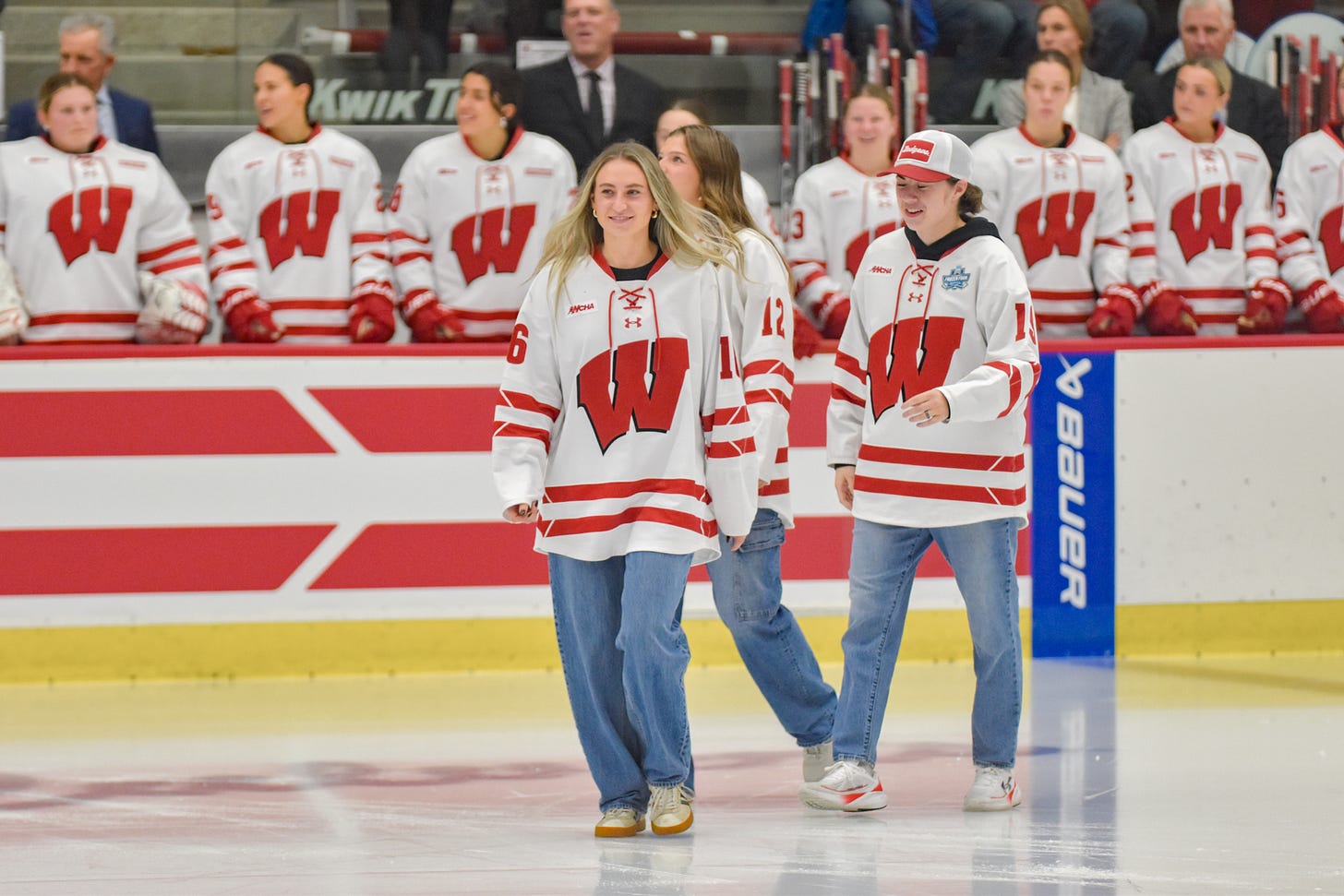 Claire Enright is walking across the ice with former teammates McKayla Zilisch and Bella Vasseur behind her