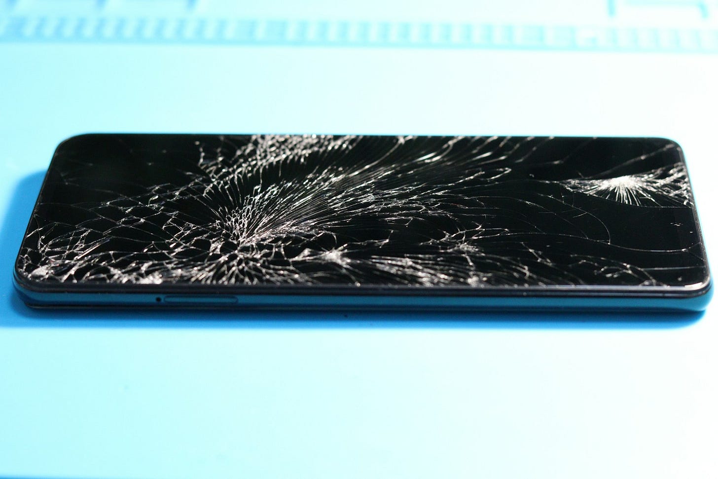A photo of a smartphone with a shattered screen.