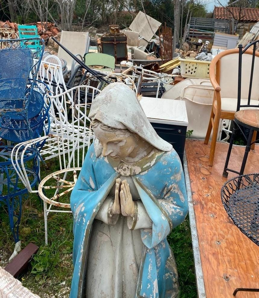 A statue of a person praying in front of a pile of chairs
AI-generated content may be incorrect.