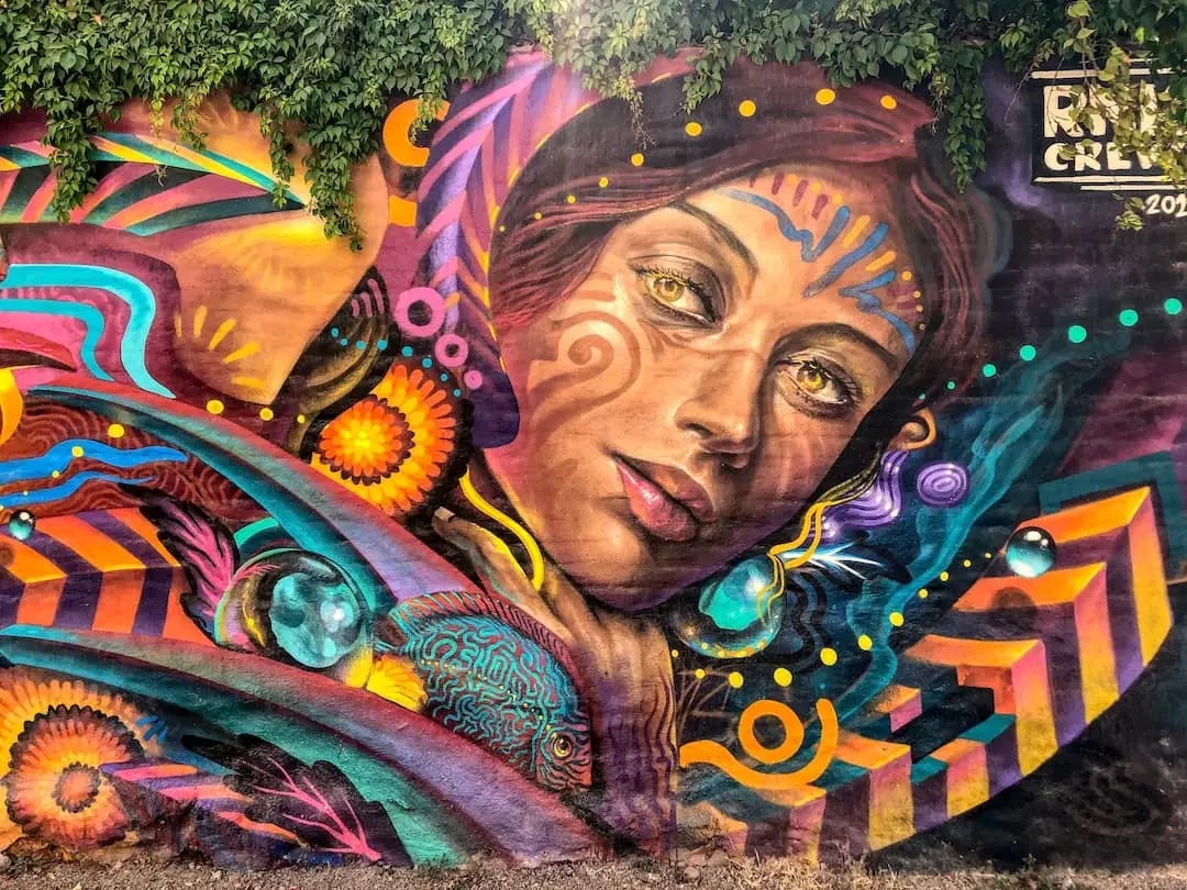 Street art - an indigenous Mexican woman's face dressed with feathers