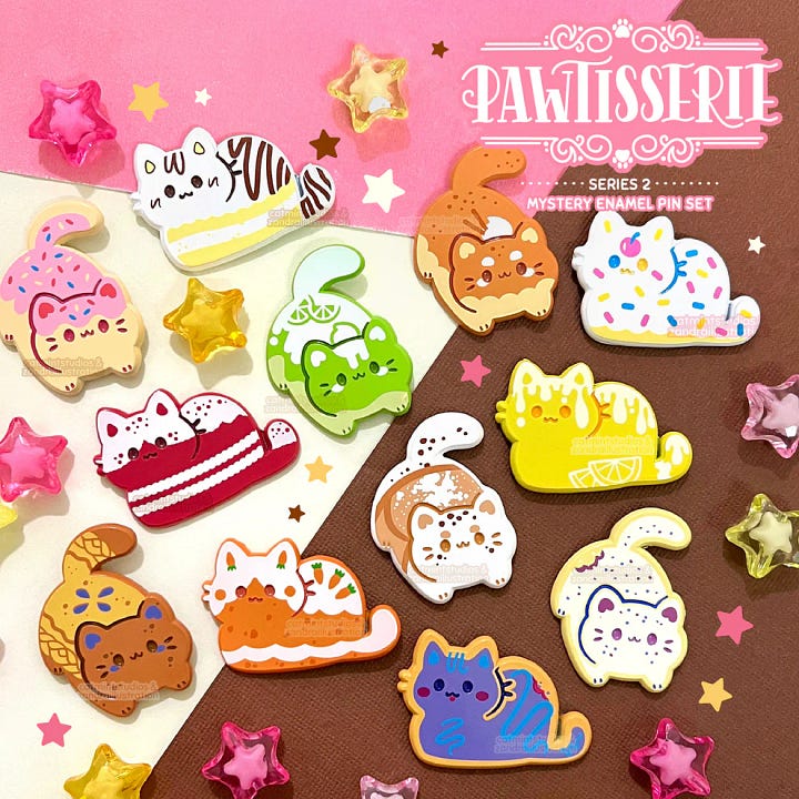 First photo: an enamel pin that says, "Booktrovert League: Lifetime Member."  Second Photo: a group of cat enamel pins in various designs that look like baked goods.