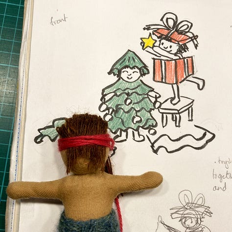 Three photos showing before, during and after the process of sewing brown wool hair onto a small handmade cloth doll made by Illustrator HannahSangjuinetti. The doll has coffee coloured skin and a blue knitted hat and is shown alongside the sketch of an illustration she will eventually be part of.