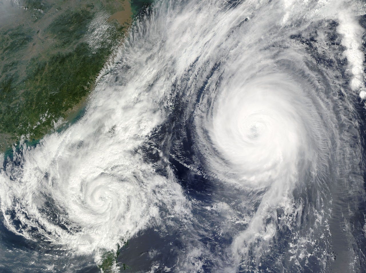 satellite image of two converging hurricanes