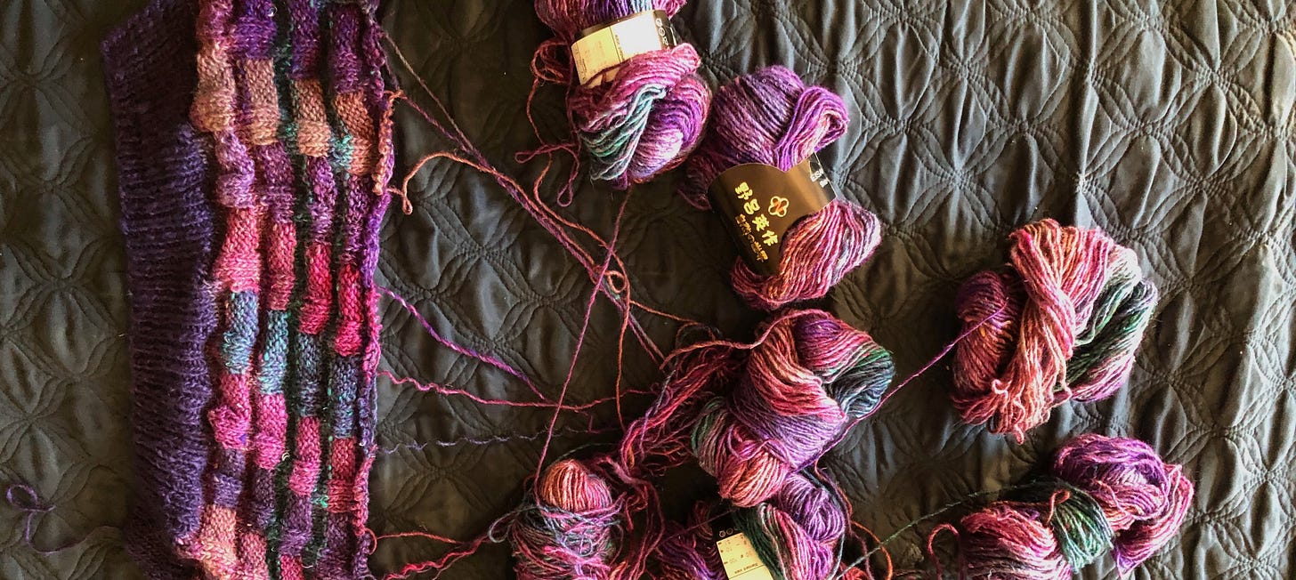A knitting project with multiple skeins of yarn coming off it, all tangled together A knitting project with multiple skeins of yarn coming off it, all tangled together