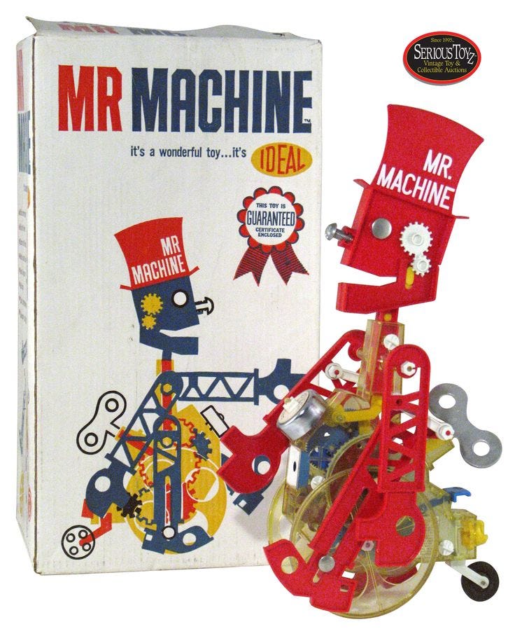 This may contain: a red and yellow toy car sitting in front of a box with the words mr machine on it