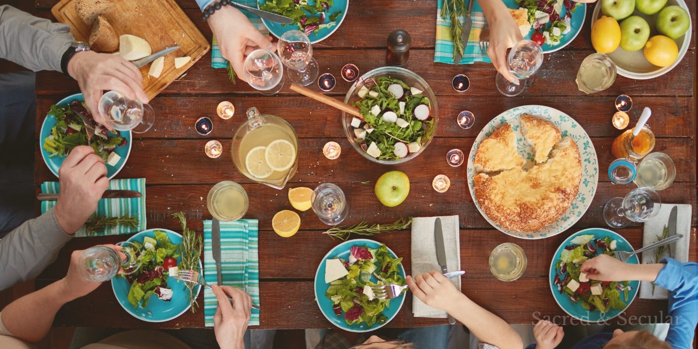 A family gathered around a dinner table in warm evening light, talking and sharing a meal together