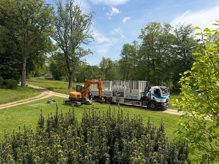 Left: a Penet delivery truck arriving at a French château with the new septic tank. Right: the new septic tank and components laid out on the lawn before installation.