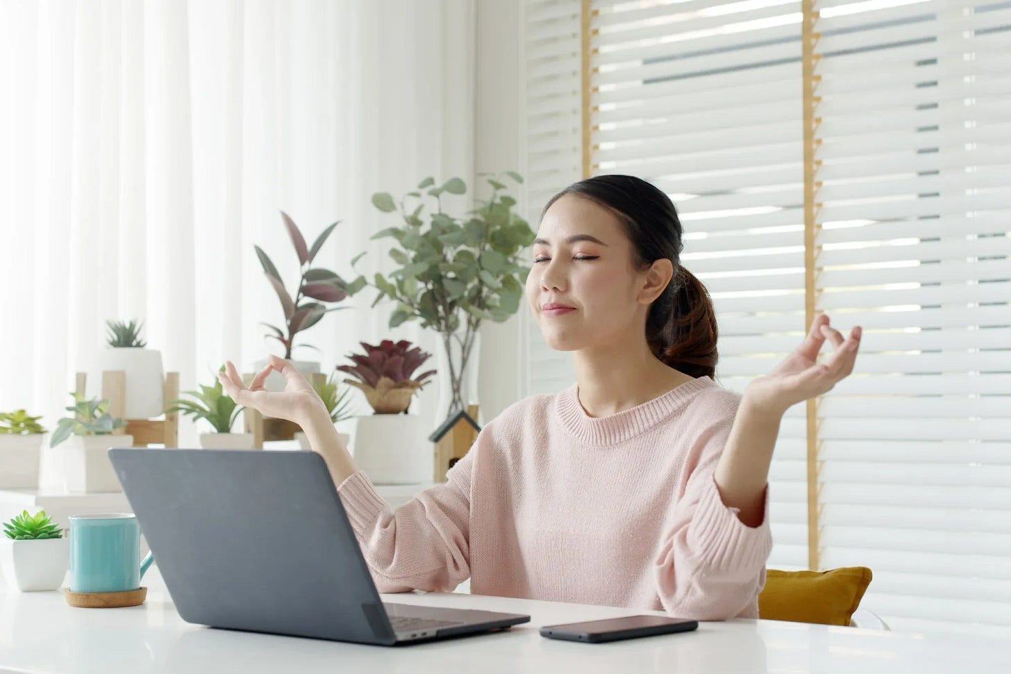 Woman remote working, meditating, and feeling in good spirit
