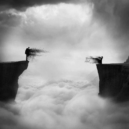 This may contain: two people standing on the edge of a cliff