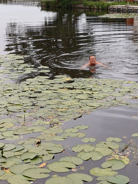 Albert and Anita swim among lily pads in the Netherlands; Dave stands nude on Baker Beach holding his dog with the Golden Gate Bridge in the distance; Jacob wades in at Denny Blaine; James walks out of the water wearing sunglasses; Craig stands naked at the helm of a boat under a red canopy.