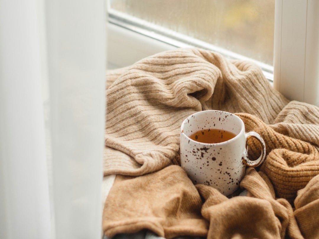 white ceramic mug on brown textile