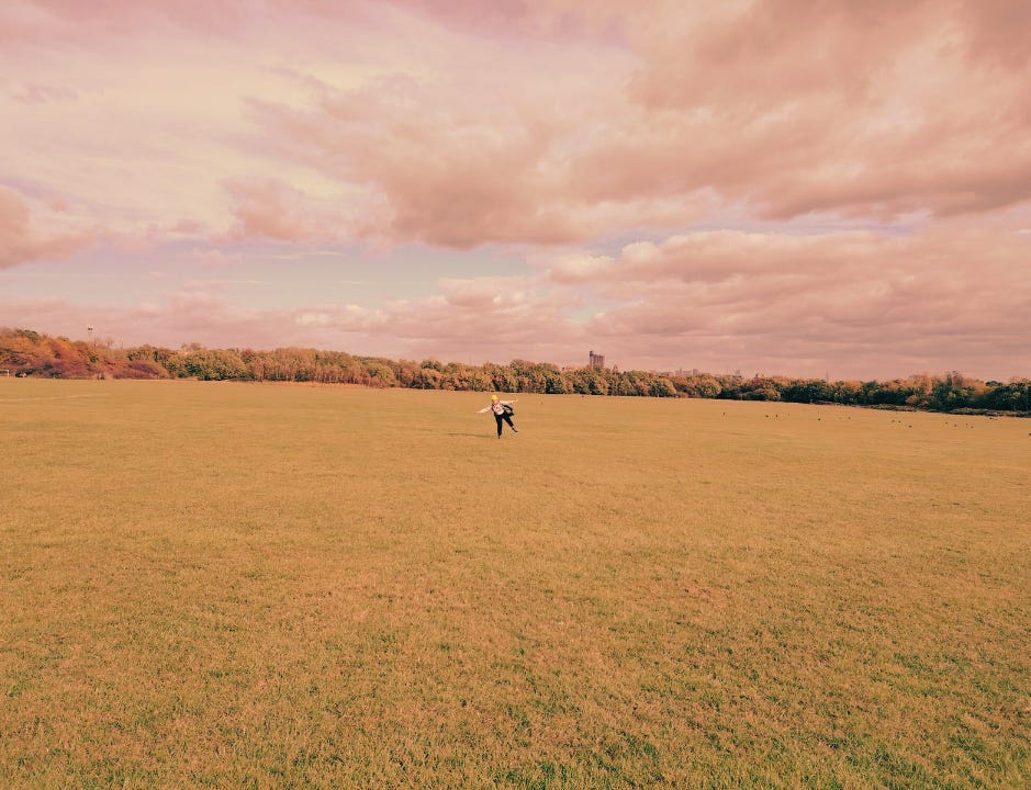 A single dancer in the middle of a green plain