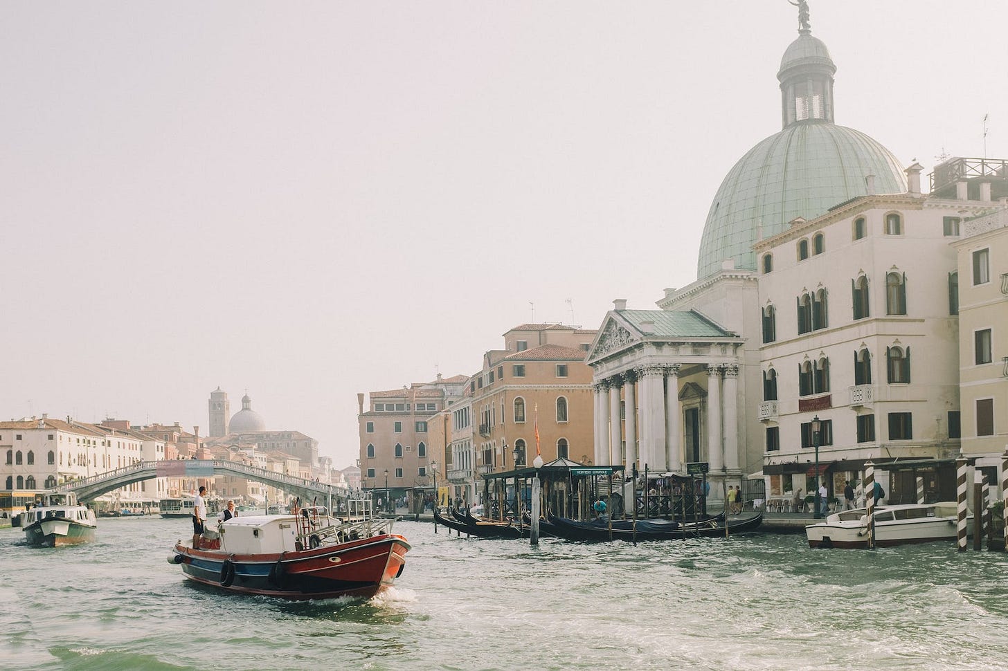 red boat on body of water near white concrete building. Photo by Leeloo Thefirst on Pexels.com