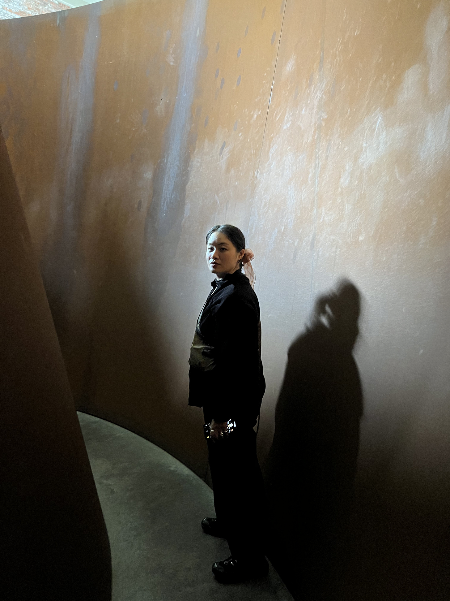 Ka Yee Chan stands inside a Dia Beacon exhibit and poses, while looking into the camera.