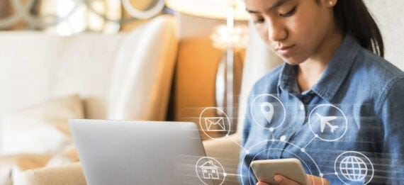 Female looking at a laptop and a smartphone