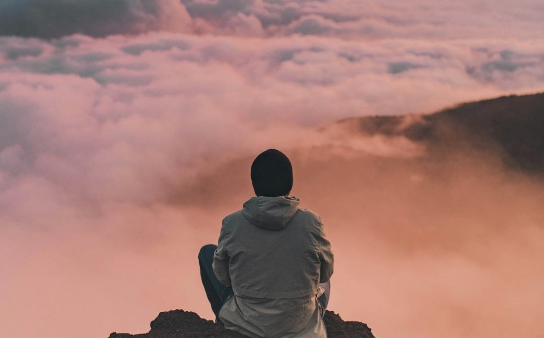 man sitting on cliff