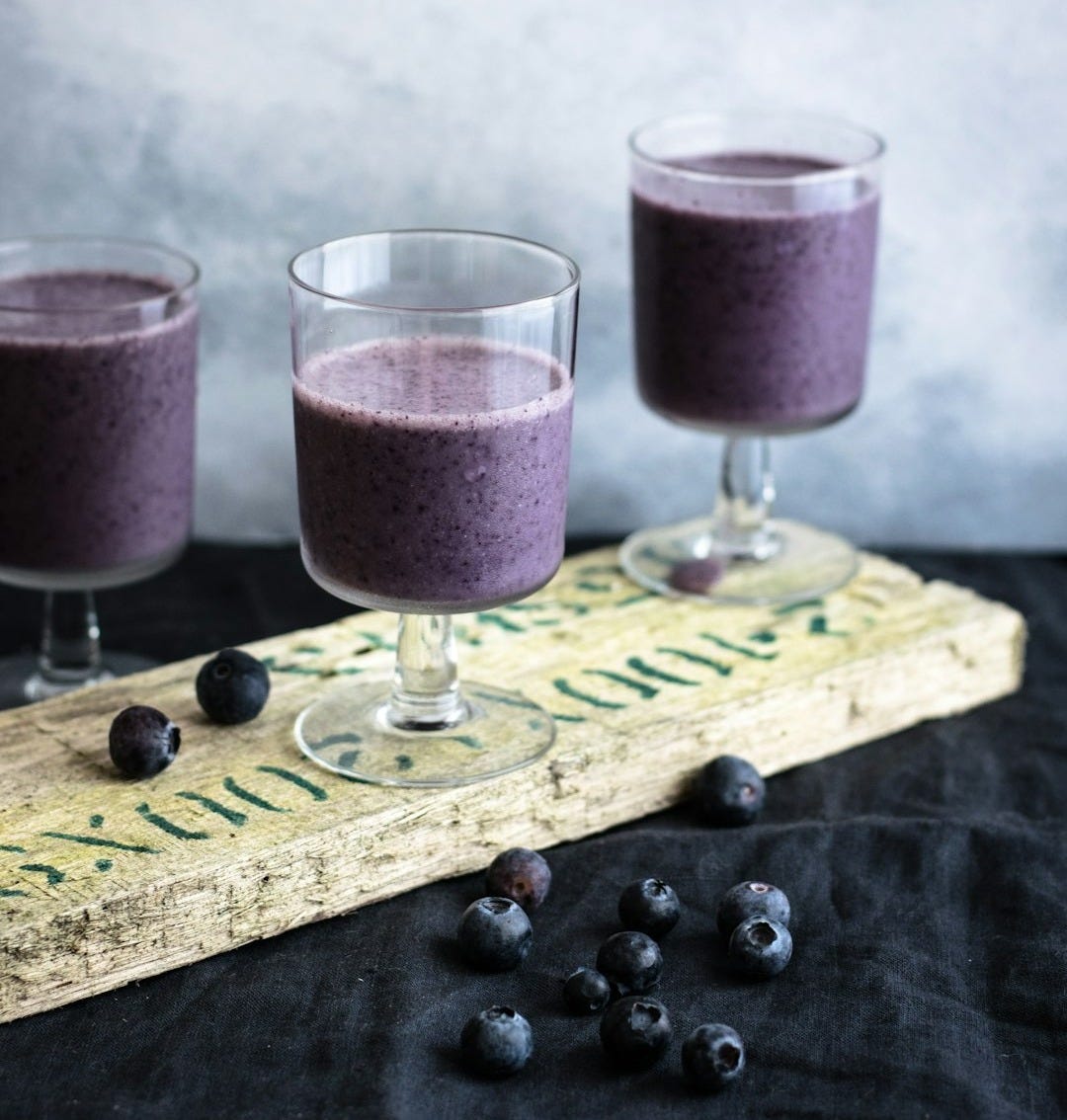 three clear drinking glasses filled with grape juices