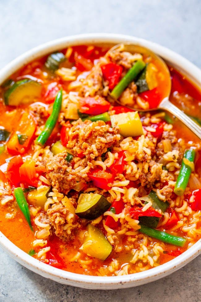A bowl of Italian sausage soup with a spoon sticking out. A bowl of Italian sausage soup with a spoon sticking out.
