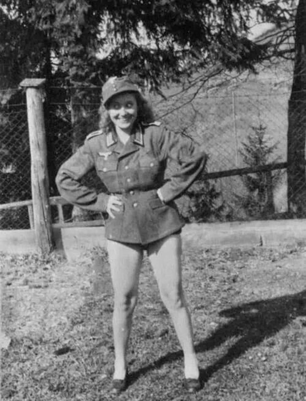 A French woman, likely a collaborator, daringly wears a German uniform. A French woman, likely a collaborator, daringly wears a German uniform.