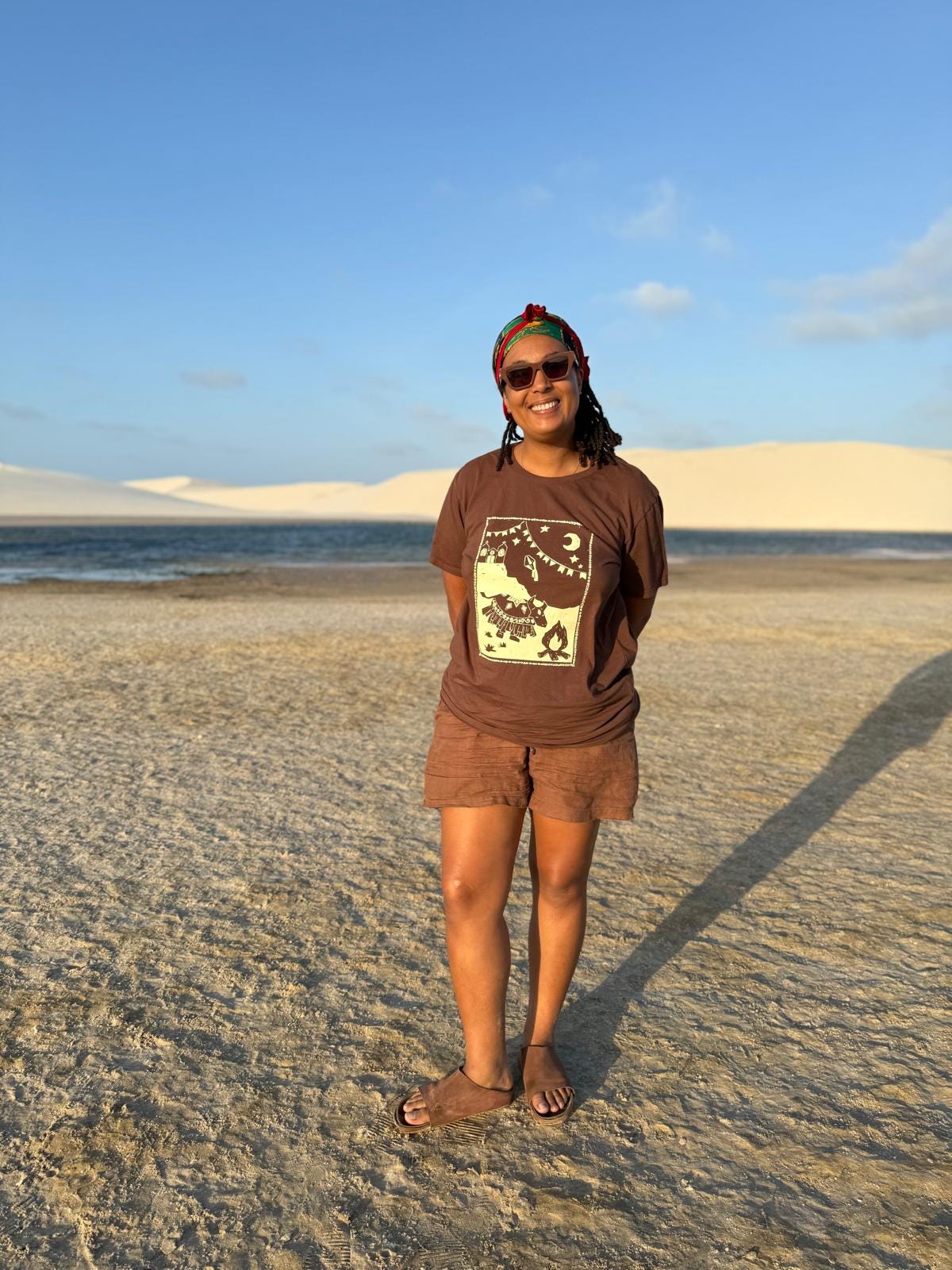 Photo of author, Coryna Ogunseitan, on white sand at a beach with the sun out