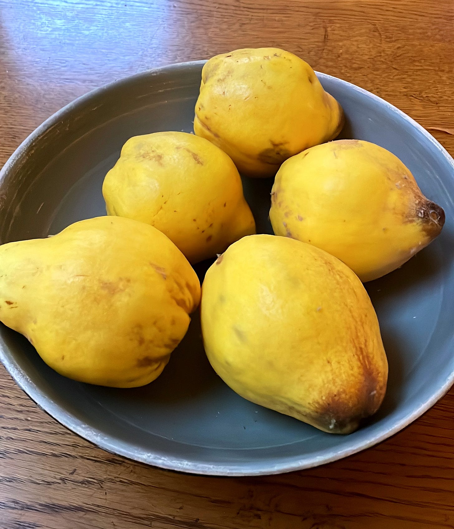 A bowl of yellow, pear-shaped fruit