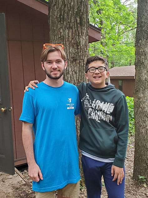 Posing with his cabin counselor and his riflery award