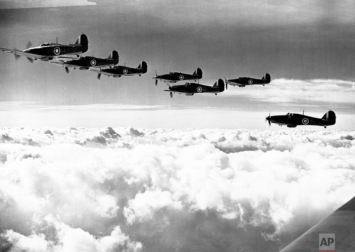 A formation of Hawker Hurricanes patrols above a picturesque cloudscape on November 27, 1940. These formidable fighters were crucial to Britain's aerial defense.
