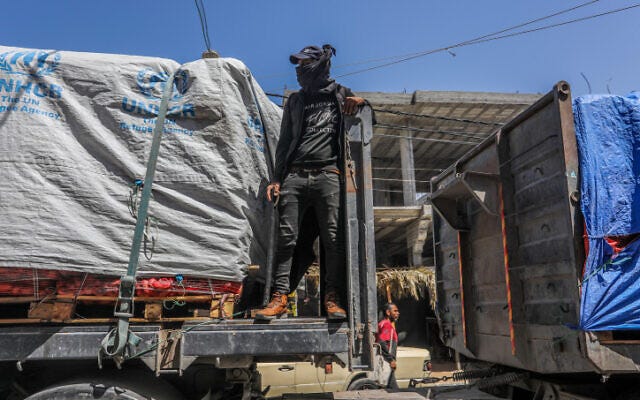 Armed and masked Palestinians seen on trucks loaded with international humanitarian aid entering Gaza via the Israeli Kerem Shalom Crossing, southern Gaza Strip, April 3, 2024. (Abed Rahim Khatib/Flash90 Armed and masked Palestinians seen on trucks loaded with international humanitarian aid entering Gaza via the Israeli Kerem Shalom Crossing, southern Gaza Strip, April 3, 2024. (Abed Rahim Khatib/Flash90