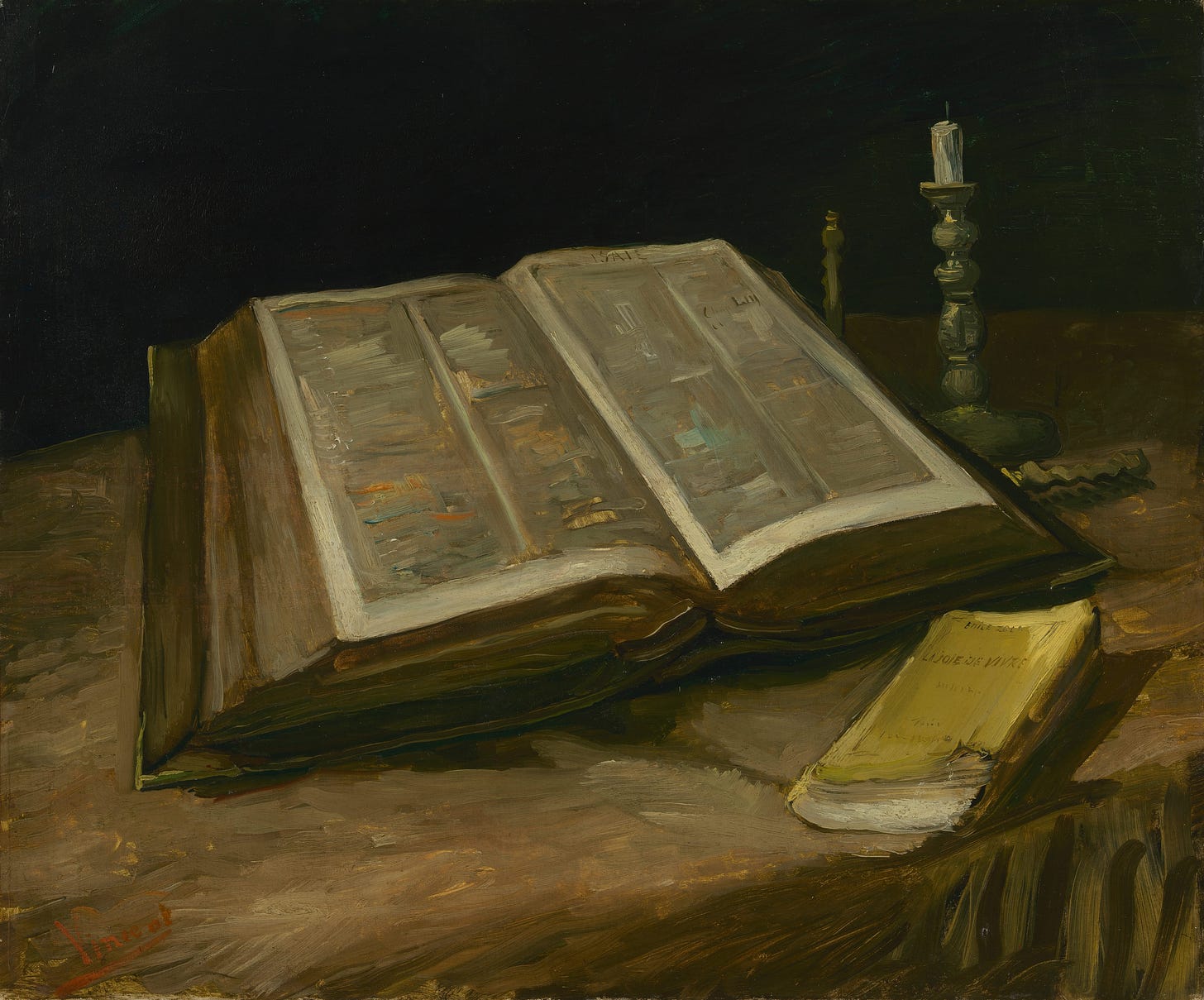 Open family Bible beside a small yellow novel Open family Bible beside a small yellow novel