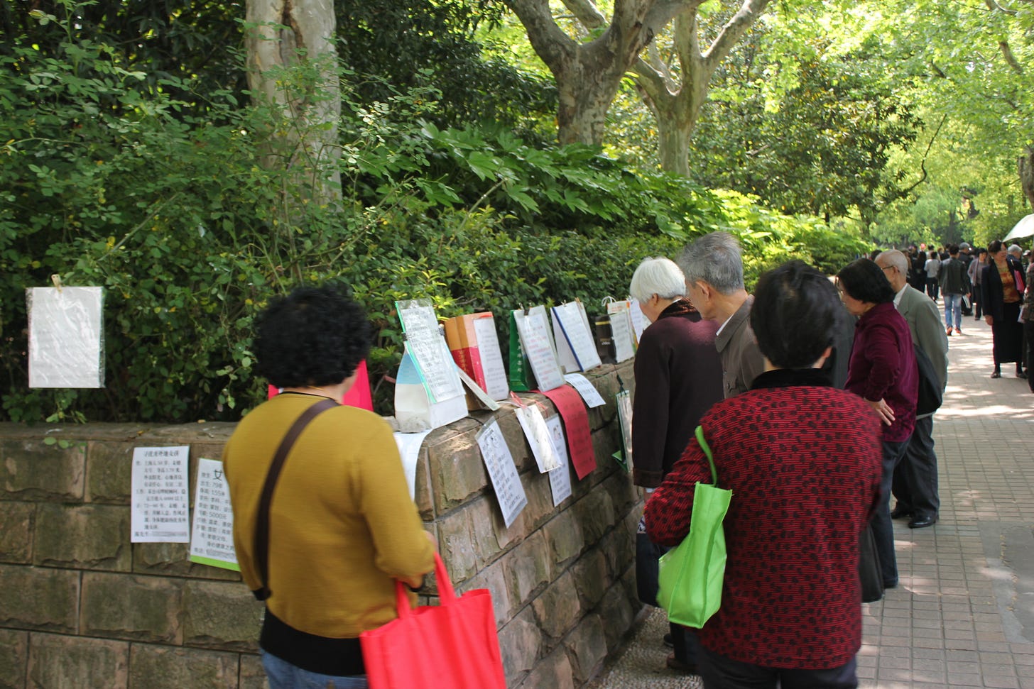 People gather around rows of marriage advertisements in Shanghai’s People’s Park.