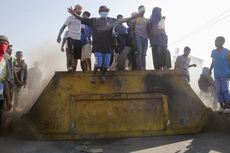 Protesters stand on a steel dumpster as they block a road during a nationwide youth-led protest in Madagascar [Zo Andrianjafy/Reuters]