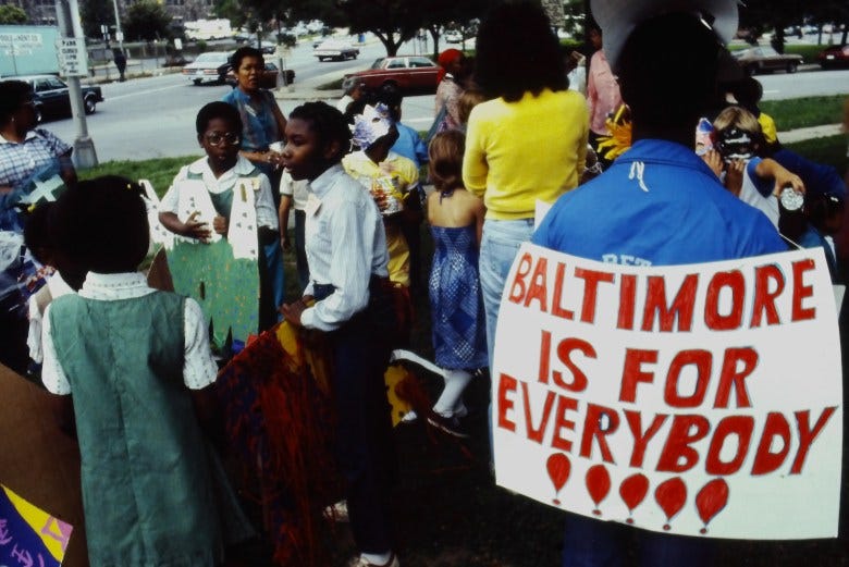 Color photograph of a group of people at an arts festival. A sign says Baltimore Is For Everybody!!!
Color photograph of a group of people at an arts festival. A sign says Baltimore Is For Everybody!!!